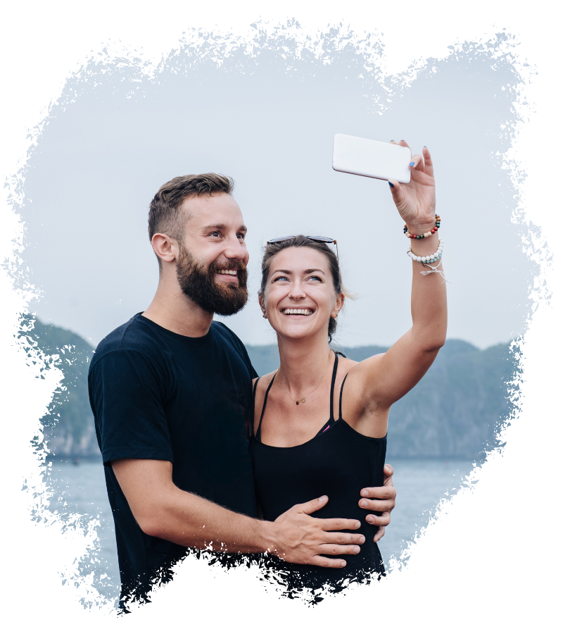 Ein Paar posiert für ein Selfie auf einem Boot, beide lächeln in die Kamera.