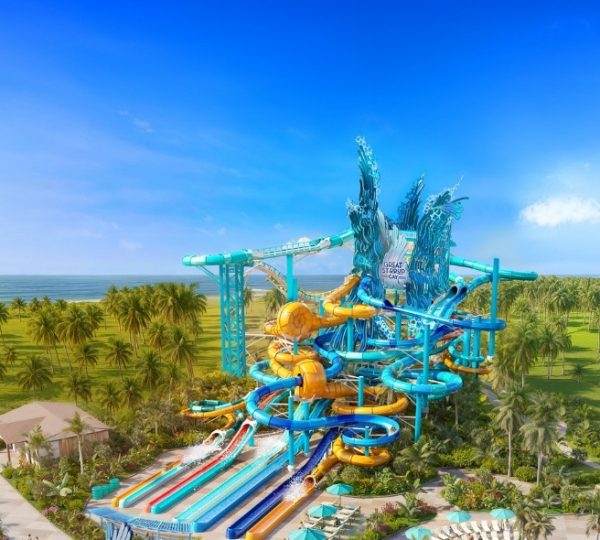 Blick auf einen Wasserpark mit verschiedenen Rutschen und Attraktionen unter blauem Himmel.